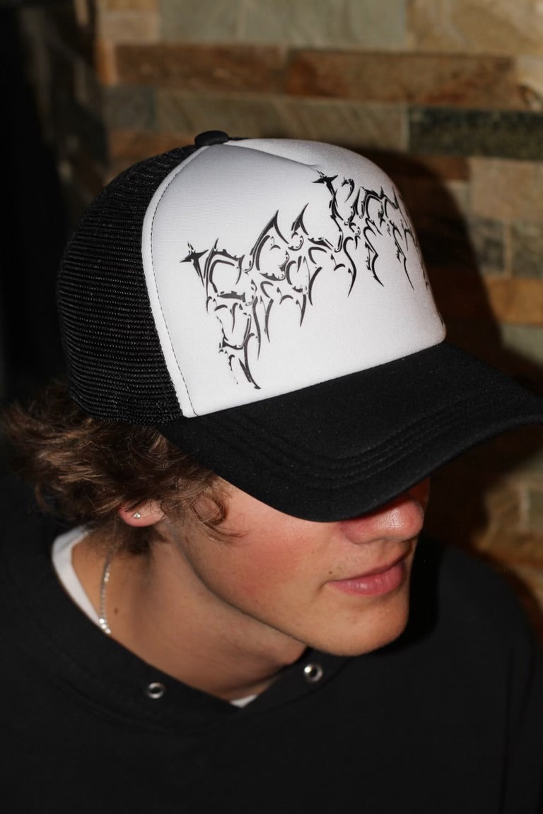 Person wearing black Sanity Global trucker hat outdoors